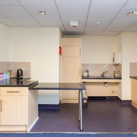 Kitchen and refreshment area with worktops, cupboards, sink, kettle, and preparation space for community events and meetings.