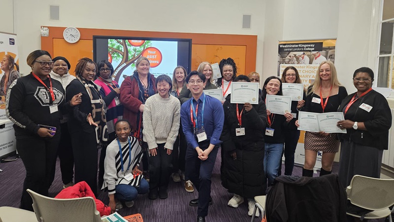 Group of participants at an ASIST suicide‑prevention training workshop holding certificates.